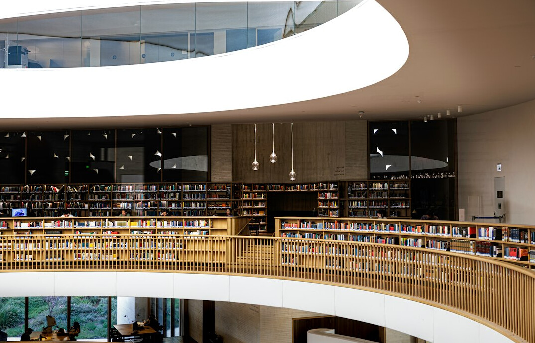 Public library reading room with tall wooden shelves